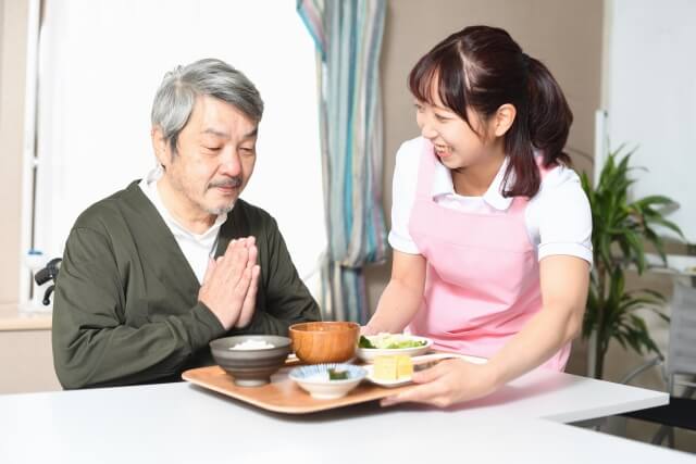 食事する人と介護士